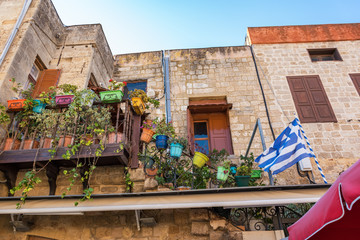 Colorful flower pots in narrow streets of old town in City of Rhodes (Rhodes, Greece)