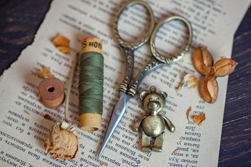 Vintage composition with old threads, scissors, wooden bobbins and dry flowers