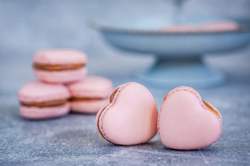 Pink hearts on blue texture background. Greeting card. Heart shaped macarons.  Valentines day concept. Soft focus. Copy space.
