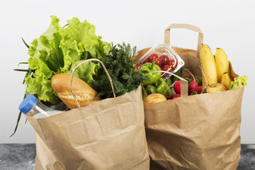 Various healthy food in paper bag on gray background