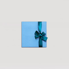 Gift box Minimalist style One blue gift box is lying on light background Photo mock up in top view with copy space