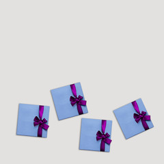 Gift box Trendy styled photo Blue gift boxes with lilac ribbons are lying on light background Photo mock up with copy space