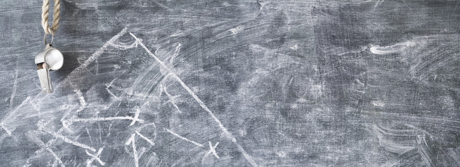 Whistle of a soccer or football referee on black board, free copy space. Grungy style large size...