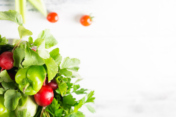 Bowl of assorted fresh colorful seasonal spring summer organic close up vegetables on white wooden shabby table background, healthy food clean eating concept, copy space