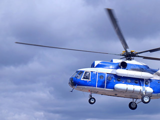 White blue helicopter on the sky background.