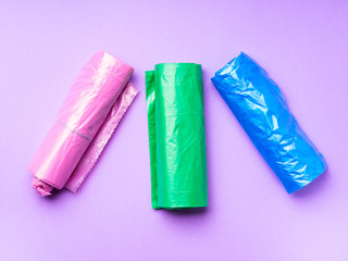 Plastic bags colorful rolls for separate waste collection disposal on purple pastel background