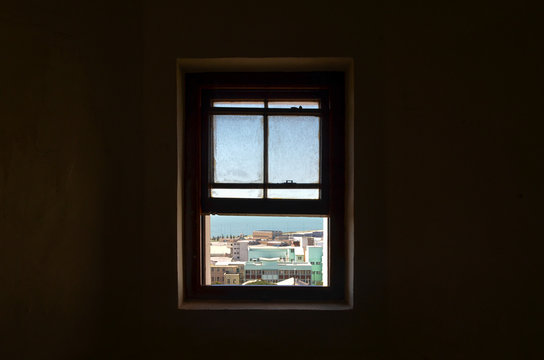 View through window in dark room on city, port elizabeth, south africa