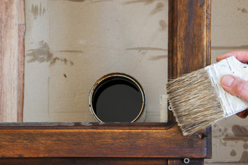 Top view of woman hand brush with colored lacquer wooden table indoors. Repair, DIY concept.