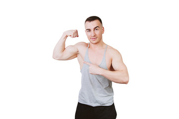 Young and sexy fitness trainer man pointing at his biceps and looking at camera over white background