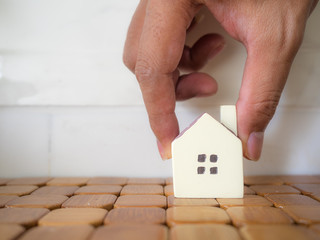 Hand is putting Small House model