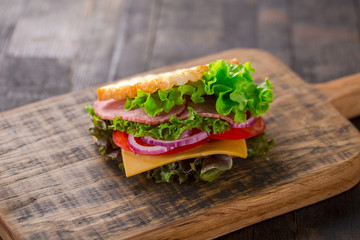 Tasty breakfast sandwich with lettuce, ham, cheese and tomato.