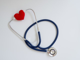 red heart using deep blue stethoscope on the white background. Concept of love and caring patient by the heart. Copy space for the text and contents