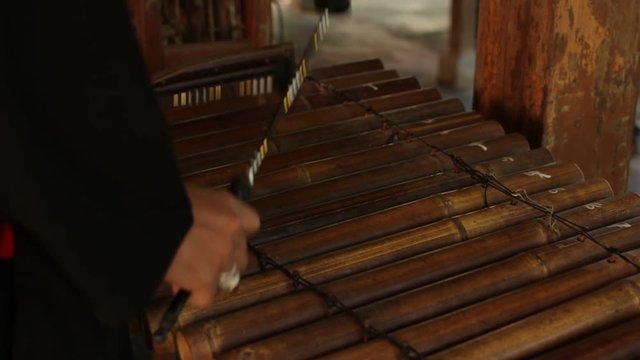 Asian Indonesian Balinese musician gamelan instrument. Closeup hands playing. Not edited, raw file.