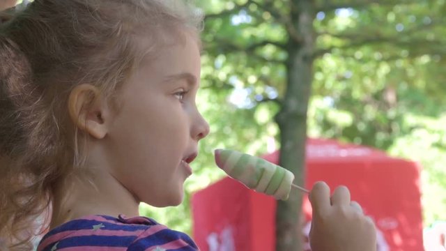 Little girl eating ice cream at an outdoor in park