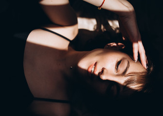 Naklejka premium The charming girl lies on the bed