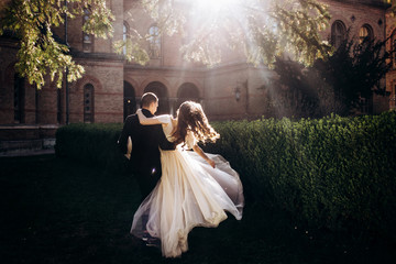 The bride and groom walking along  park