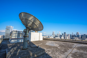 satellite dish antennas with city skyline