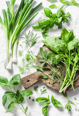 Garden herbs - spinach, basil, thyme, rosemary, sage, mint, onion, garlic on a light background, top view. Fresh food ingredients. Flat lay © okkijan2010