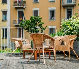 Fototapeta na wymiar Wooden table and chairs on an outdoor terrace in a residential neighbourhood during the summer.