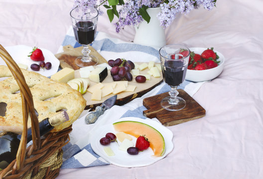 Summer picnic with cheese, wine, fruits and bread.