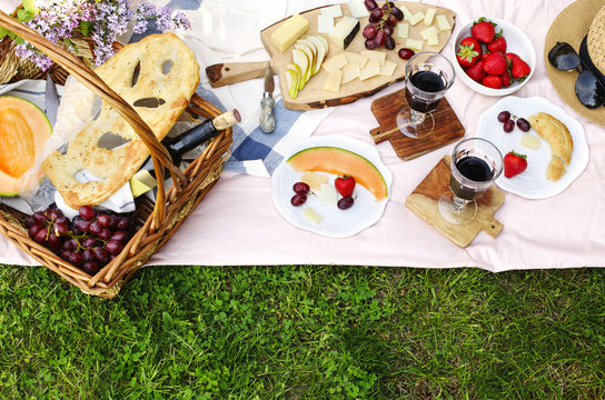 Summer picnic with cheese, wine, fruits and bread.