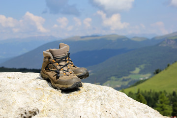 Woman hiking boots at Alps mountain landscape background