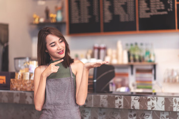 Successful SME Owners Standing and Present Something in Her Hand (You can montage some text or product to present) with Cafe or Restaurant Background