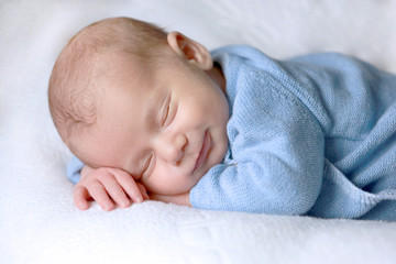 Bébé nouveau-né dort paisiblement avec un sourire