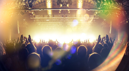 Concert spectators in front of a bright stage with live music