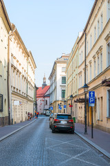 Naklejka na ściany i meble European street with parked cars near the sidewalk