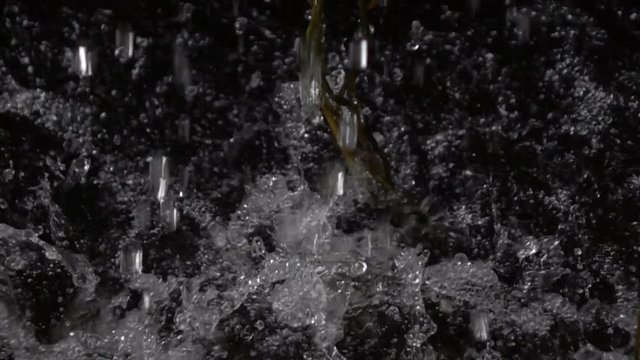 Rain falling drops on splashing water surface, slow motion