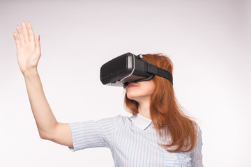 Happy young red-haired woman using a virtual reality headset