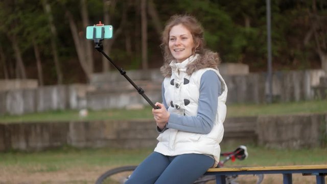 pretty girl smile take self picture selfie with smart phone mobile on the park