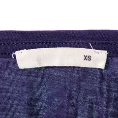 Size XS textile clothes label on blue cotton background