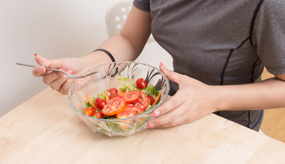 Enjoyed Asian woman eating vegetable salad.