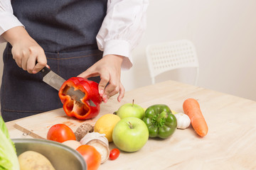 Young Woman Cooking Healthy Food   and Vegetable Salad in the kitchen at home.  Healthy Lifestyle.