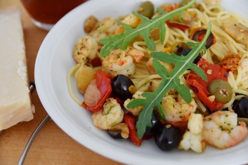 Nudeln, Shrimps, Oliven, Paprika mit Rucola