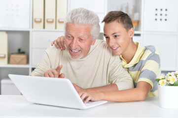portrait of  boy and  grandfather with a laptop 