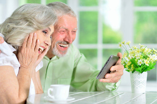 portrait of a happy senior couple using tablet