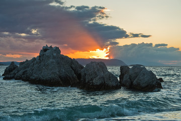 Sea rocks with dramatic clouds at sunset , Kastani Mamma Mia beach, island of Skopelos, Greece