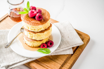 Trendy asian food, Fluffy Japan souffle pancakes, hotcakes with maple syrup and raspberry light concrete background copy space