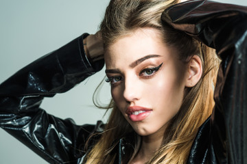 Fototapeta na wymiar Makeup look for woman with soft skin. Sexy woman with stylish long hair in black leather coat. Trendy girl with makeup on sensual face. Beauty and hairdresser. Fashion cosmetics for skincare.