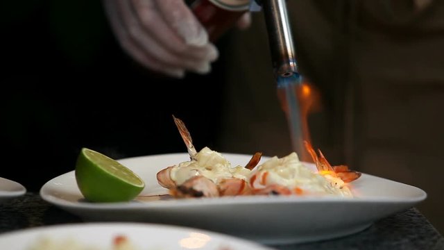 Chef serves shrimp with sauce