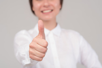 Young business girl shows thumb up isolated