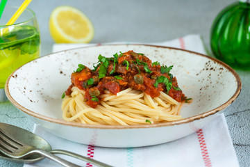 Spaghetti with sardines in tomato sauce garnished with fresh parsley