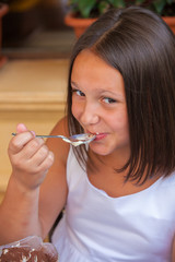 Fototapeta premium girl in a cafe eating an ice cream with a glass