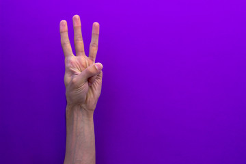 Three counting hands isolated on purple background