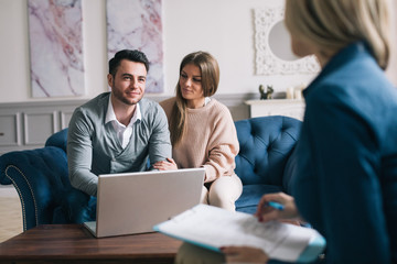 Happy couple planning their future while consulting with insurance agent in their home.