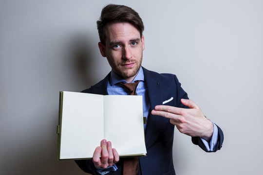 Business man showing blank note. Studio portrait isolated.