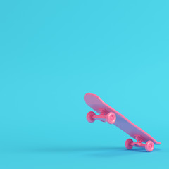 Pink low poly skateboard deck on bright blue background in pastel colors